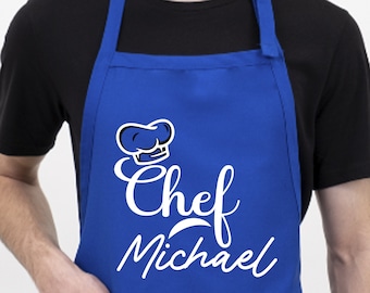 May include: A blue apron with a white chef hat and the text "Chef Michael" in a white cursive font.