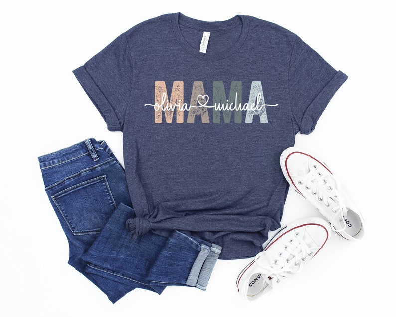 May include: A navy blue t-shirt with the word "MAMA" in colorful, distressed letters. The text "Olivia & Michael" is written in white script below the word "MAMA".