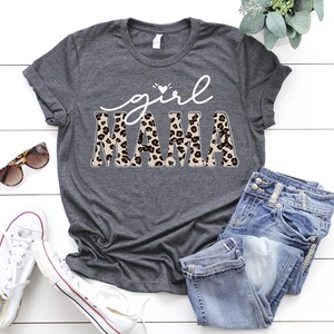 May include: A gray t-shirt with the text "girl mama" in white with a leopard print design.