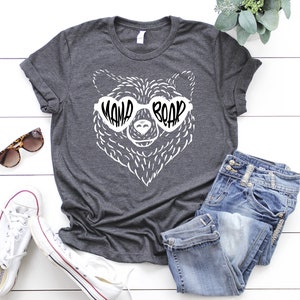 May include: A dark gray t-shirt with a white bear wearing heart-shaped sunglasses that say "Mama Bear".
