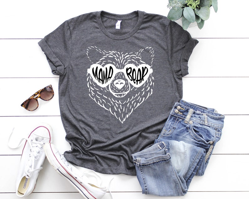 May include: A dark gray t-shirt with a white bear wearing heart-shaped sunglasses that say "Mama Bear".