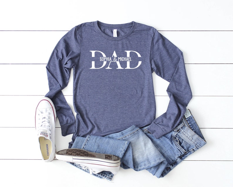 Puede incluir: Una camiseta de manga larga azul marino con la palabra "DAD" en letras blancas. El texto "Sophia & Michael" est&aacute; escrito en letras blancas m&aacute;s peque&ntilde;as debajo de la palabra "DAD".