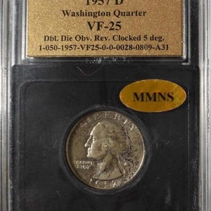 May include: A 1957 D Washington Quarter coin, graded VF-25, in a protective case. The coin shows a profile of George Washington and the inscriptions "LIBERTY" and "IN GOD WE TRUST". The holder has a gold label with details.
