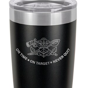 May include: Black stainless steel tumbler with a silver lid. The tumbler has a white engraved design of a naval insignia with the text "On Time * On Target * Never Quit".