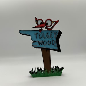 May include: A red bird with glasses points to a blue sign that says "Tulgey Wood". The sign is on a brown wooden post and is surrounded by green grass.