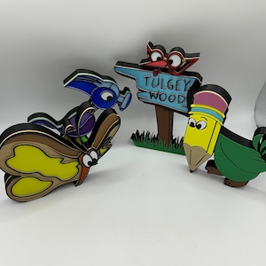 May include: A set of four colorful wooden figurines, including a butterfly, a pencil, a bird, and a sign that reads "Tulgey Wood".