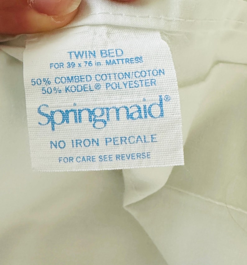 May include: A white fabric tag with blue text reads "TWIN BED FOR 39 x 76 in. MATTRESS." The tag also states the fabric is 50% combed cotton and 50% KODEL&reg; polyester. The brand name "Springmaid" is visible.