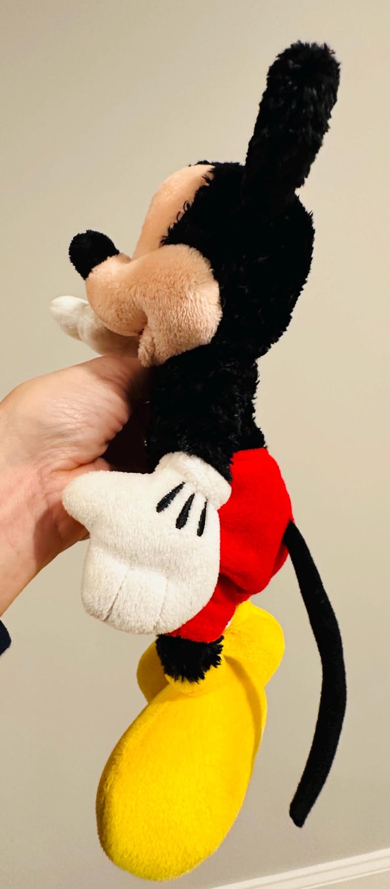 Puede incluir: Un peluche de Mickey Mouse, con cabeza y orejas negras, cara beige y guantes blancos. El juguete tiene pantalones cortos rojos y zapatos amarillos. El juguete mide aproximadamente 30 cm de alto.