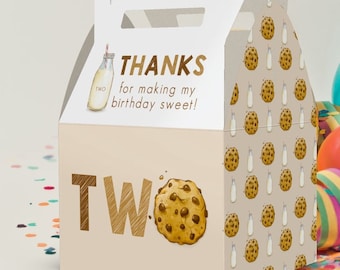 May include: A beige gable box with a handle, decorated with a chocolate chip cookie and the word "TWO" in gold. The box has a pattern of cookies and milk bottles. Text on the box reads "THANKS for making my birthday sweet!"