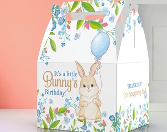 May include: A white favor box with a blue and green floral design. The box features a cartoon bunny holding a blue balloon and the text "It's a little Bunny's Birthday!" and "Thank you for hopping by!"