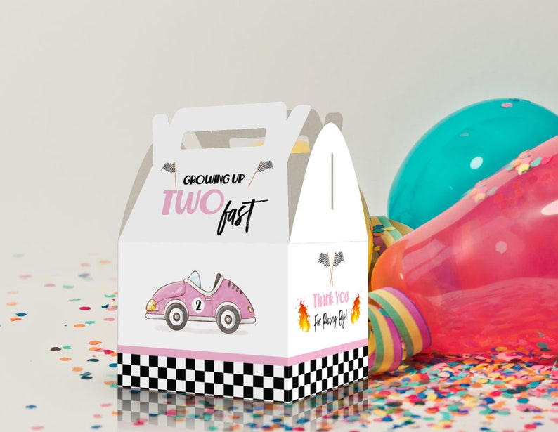May include: White favor box with a pink race car and the text "Growing Up Two Fast". The box has a checkered pattern and pink accents.