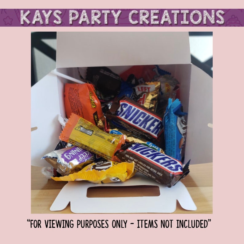 Op de afbeelding: Een witte kartonnen doos gevuld met verschillende chocolade repen, waaronder Snickers, Twix en 100 Grand. De doos heeft een handvat en de tekst "FOR VIEWING PURPOSES ONLY - ITEMS NOT INCLUDED" staat onderaan gedrukt.