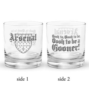 May include: Two clear, lowball glasses with black text. One glass features the word "Arsenal" above a crest with "Gunners" and a soccer field. The other glass says "Wooh to, Oooh to be, Dooly to be a Gooner!"