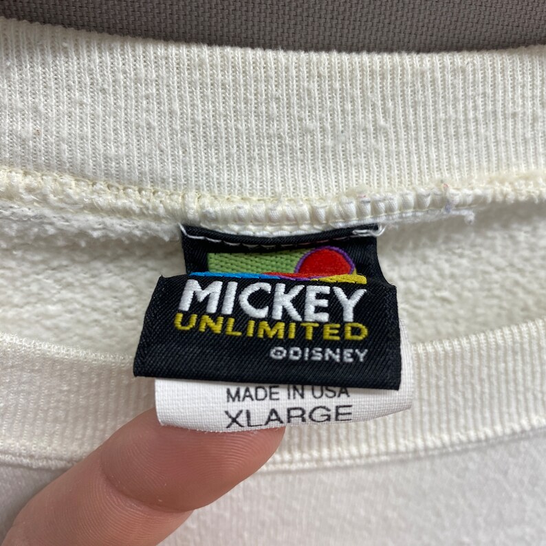 May include: White sweatshirt with a black tag that reads "Mickey Unlimited &copy;Disney" and "Made in USA XLarge".