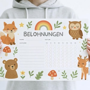 Könnte beinhalten: Eine weiße Belohnungstafel mit Illustrationen von Waldtieren, darunter ein Fuchs, ein Bär, eine Eule und ein Reh. Die Tafel hat einen Regenbogen, Sterne und das Wort "BELOHNUNGEN" oben, mit Feldern für Namen, Aufgaben und Daten.