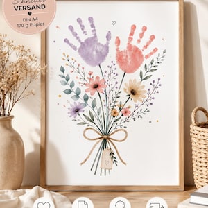 Könnte beinhalten: Ein gerahmter Kunstdruck mit einem Blumenstrauß, bei dem die Blüten durch zwei Handabdrücke in Violett und Koralle ersetzt sind. Die Stiele sind mit einer beigen Schleife und einem kleinen Anhänger mit Herzsymbol zusammengebunden.