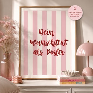 Peut inclure: Une affiche verticale encadrée avec un fond à rayures verticales rose clair et crème, portant le texte rouge en cursive "Dein Wunschtext als Poster". Un autocollant rose circulaire en haut à droite contient un cœur et du texte.