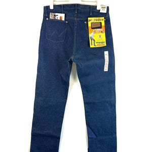 May include: A pair of blue denim jeans with a Wrangler label and a Pro Rodeo tag. The jeans have a classic straight leg fit and a five-pocket design.