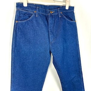 May include: A pair of blue denim jeans with a classic straight leg fit. The jeans have a button fly and five pockets.