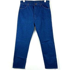 May include: A pair of blue denim jeans with a classic straight leg fit. The jeans have a button fly and belt loops.