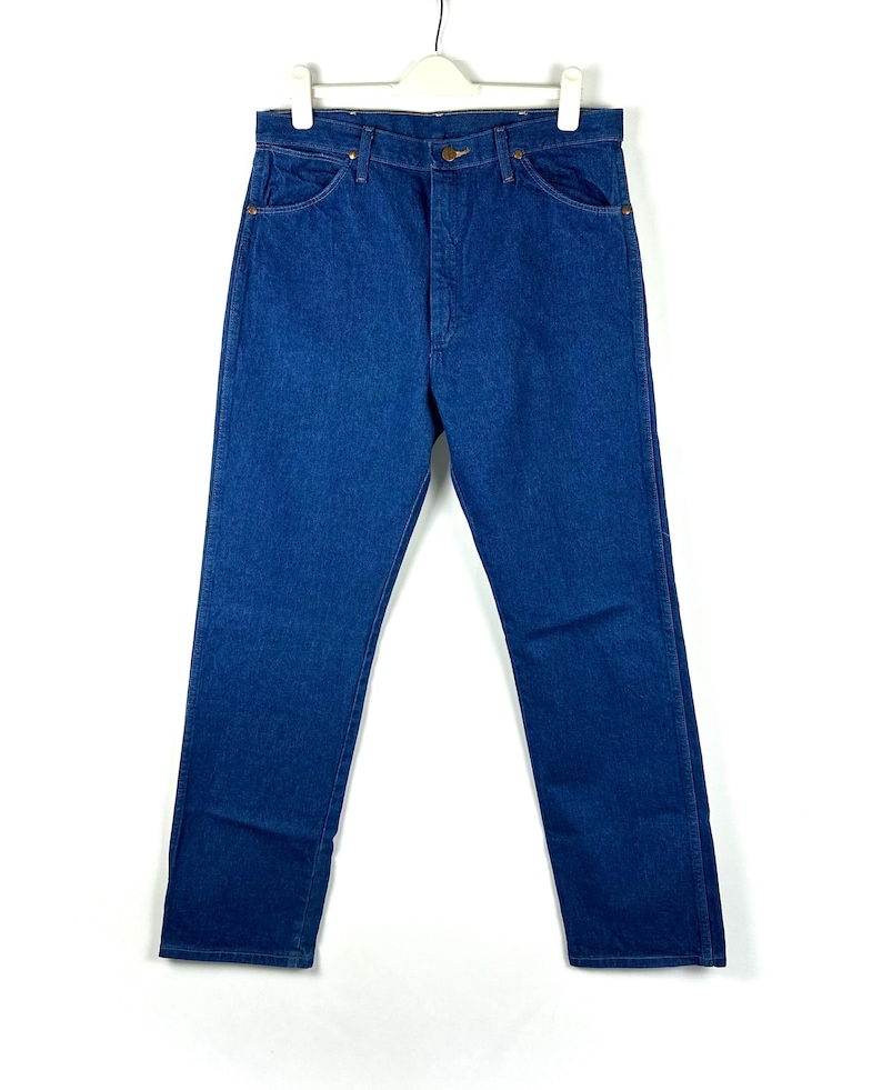 May include: A pair of blue denim jeans with a classic straight leg fit. The jeans have a button fly and belt loops.