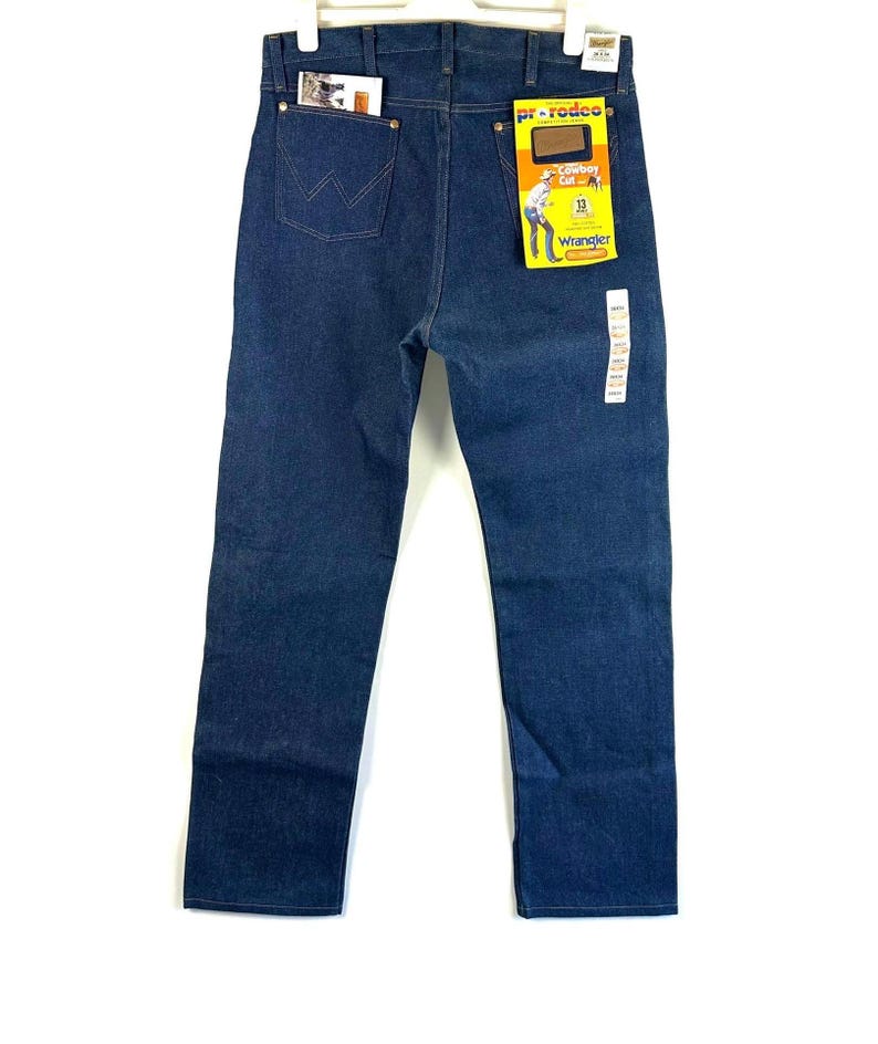 May include: A pair of blue denim jeans with a Wrangler label and a Pro Rodeo tag. The jeans have a classic straight leg fit and a five-pocket design.