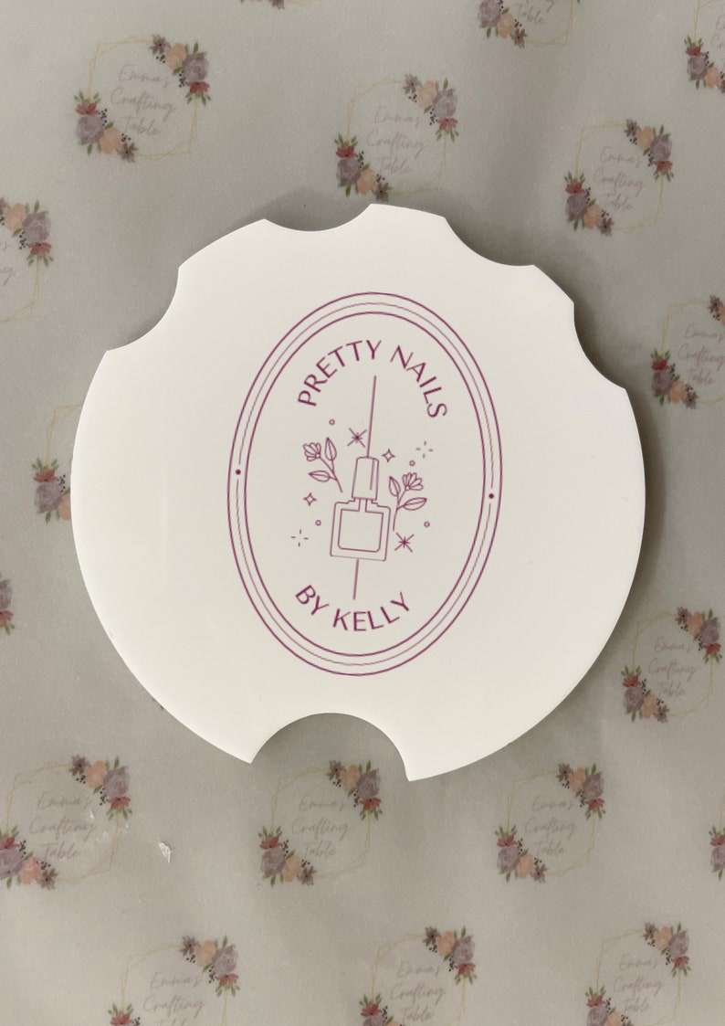 May include: A white, scalloped-edge nail art palette with the text "PRETTY NAILS BY KELLY" in a burgundy oval design. The design includes a nail polish bottle and floral accents.