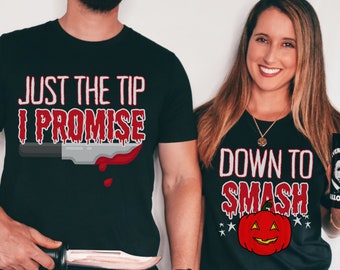 May include: Two black t-shirts with Halloween themed graphics. The first shirt says "Just the tip I promise" with a dripping bloody knife. The second shirt says "Down to Smash" with a smiling pumpkin.