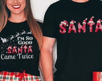 Può includere: Due magliette nere con testo a tema natalizio. La prima maglietta dice "I'm so good Santa came twice". La seconda maglietta dice "Santa" con ogni lettera decorata con un cappello di Babbo Natale. Le magliette sono indossate da due persone che indossano pantaloni da pigiama a quadri rossi e verdi. Il testo "Ogni maglietta venduta separatamente. Nessun pantalone incluso." è nella parte inferiore dell'immagine.