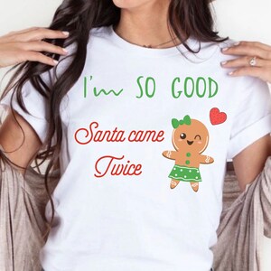 May include: White t-shirt with a gingerbread person graphic and the text "I'm so good Santa came twice".