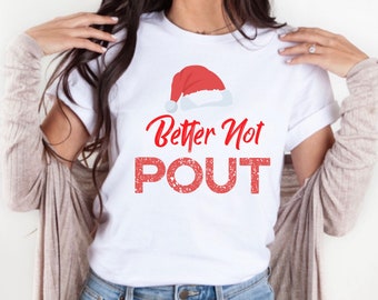 May include: White t-shirt with a red Santa hat graphic and the text "Better Not POUT" in red.