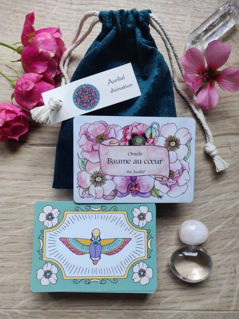 May include: A teal velvet bag with a white tag that reads "Auriel divination" and a card with a floral design and the text "Oracle Baume au coeur Par Auriel".