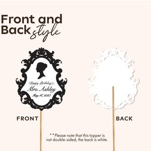 May include: A black and white cake topper with a decorative frame design. The front features a silhouette, the text "Happy Birthday Mrs. Ashley May 16, 2027", and is mounted on a wooden stick. The back is white.