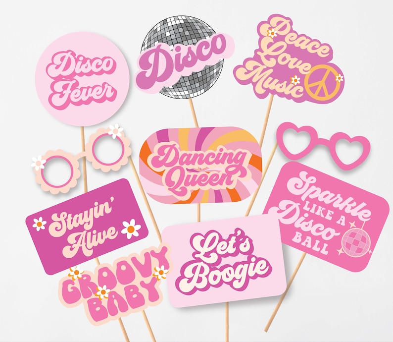 May include: A collection of pink and white photo booth props with disco-themed phrases like "Disco Fever," "Dancing Queen," and "Let's Boogie." Includes heart-shaped glasses and a disco ball prop. Wooden sticks attached.