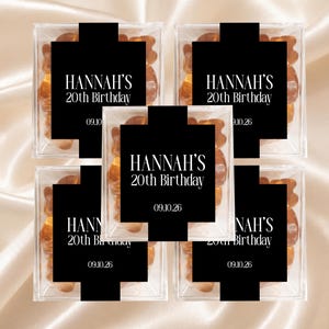 May include: Five clear square plastic boxes filled with orange gummy bears. Each box features a black rectangular label with white text reading HANNAH'S 20th Birthday and the date 09.10.26 centered on the front of the packaging.