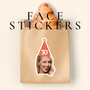Puede incluir: Una bolsa de papel marrón que contiene un cruasán, con el texto FACE STICKERS impreso encima. Un adhesivo de una persona con un gorro de fiesta color coral con el número 30 está pegado en la bolsa, mostrando una cara que guiña un ojo con labios rojos.