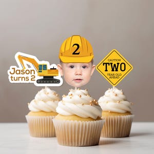 May include: Three cupcakes topped with construction-themed decorations. One features a yellow excavator with the text Jason turns 2, another shows a child wearing a yellow hard hat with the number 2, and the third is a yellow sign reading CAUTION TWO YEAR OLD AHEAD.