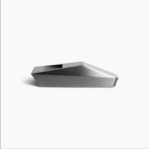 May include: A silver whistle with a geometric design. The whistle is made of metal and has a smooth, brushed finish.