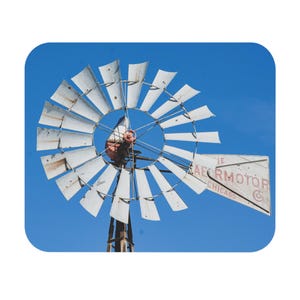 May include: A white windmill with a red and black Aermotor sign against a bright blue sky. The sign reads "Aermotor Chicago".