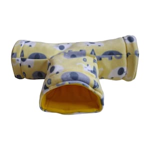Peut inclure: Un tunnel pour animaux en forme de T fabriqué en tissu polaire jaune doux. L'extérieur présente un motif répétitif de silhouettes d'éléphants gris et blancs. L'intérieur du tunnel est doublé d'une matière polaire jaune vif unie.