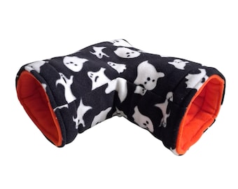 May include: An L-shaped pet tunnel made of soft black fleece fabric featuring a repeating white ghost pattern. The interior of the tunnel is lined with a solid bright orange fleece fabric, creating a contrast between the exterior and interior.