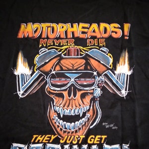 May include: Black t-shirt with a graphic of a skull wearing sunglasses and a motorcycle helmet. The text "Motorheads! Never Die They Just Get Rebuilt!" is printed on the shirt.