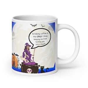 Könnte beinhalten: Eine weiße Keramik-Kaffeetasse mit einem Halloween-Motiv. Eine Hexe in lila Kleidung und eine schwarze Katze sind im Design zu sehen. Der Text auf der Tasse lautet "Drinking coffee is the ONLY thing keeping me from turning you into a toad!!!!"