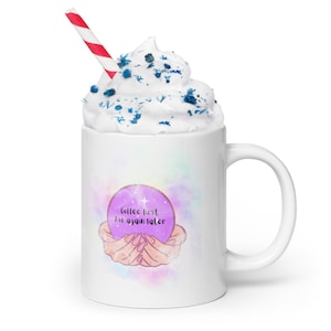 Könnte beinhalten: Weiße Keramik-Kaffeetasse mit einem Design aus einer violetten Kristallkugel. Die Kristallkugel hat einen Stern und den Text "Coffee first ask again later".