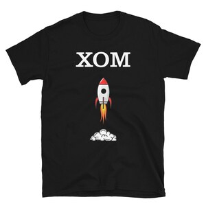 Könnte beinhalten: Schwarzes T-Shirt mit weißem Text "XOM" und einer Cartoon-Rakete mit einer Rauchwolke darunter.