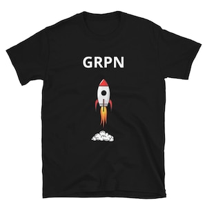 May include: Black t-shirt featuring the word "GRPN" in white block letters above a cartoon rocket ship. The rocket is white with a red tip, and flames and smoke emanate from its base.