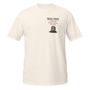 May include: Cream-colored t-shirt featuring the text "MAX PAIN CAPITAL - WHERE OPTIONS GO TO DIE" above a tombstone graphic with "RIP" on it. The shirt has short sleeves and a crew neck.