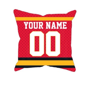 May include: Red decorative pillow shaped like a jersey, featuring the text "YOUR NAME" above the number "00" in white. The jersey design includes yellow and black stripes.