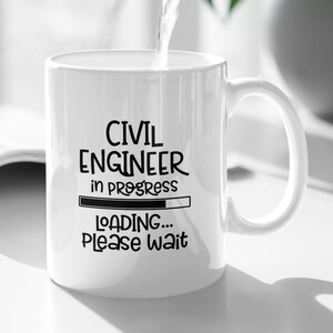 Könnte beinhalten: Weiße Keramiktasse mit dem Text "CIVIL ENGINEER in progress LOADING... PLEASE WAIT" in Schwarz. Wasser wird aus einem silbernen Krug in die Tasse gegossen. Im Hintergrund befindet sich eine grüne Pflanze.
