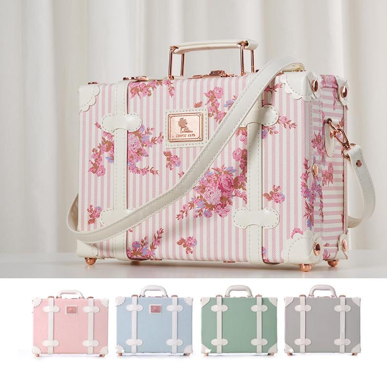 May include: Two pink and white vintage-style suitcases with gold accents. The larger suitcase measures 15.4 inches wide, 11.2 inches tall, and 7.5 inches deep. The smaller suitcase measures 12 inches wide, 8.3 inches tall, and 12 inches deep.